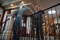 チャップリンの看板と並ぶ岡部章蔵。