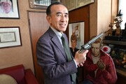 「ダーティハリー」のヒット記念品である銃を持つ社長・岡部章蔵。