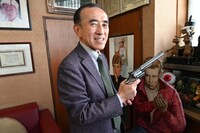 「ダーティハリー」のヒット記念品である銃を持つ社長・岡部章蔵。