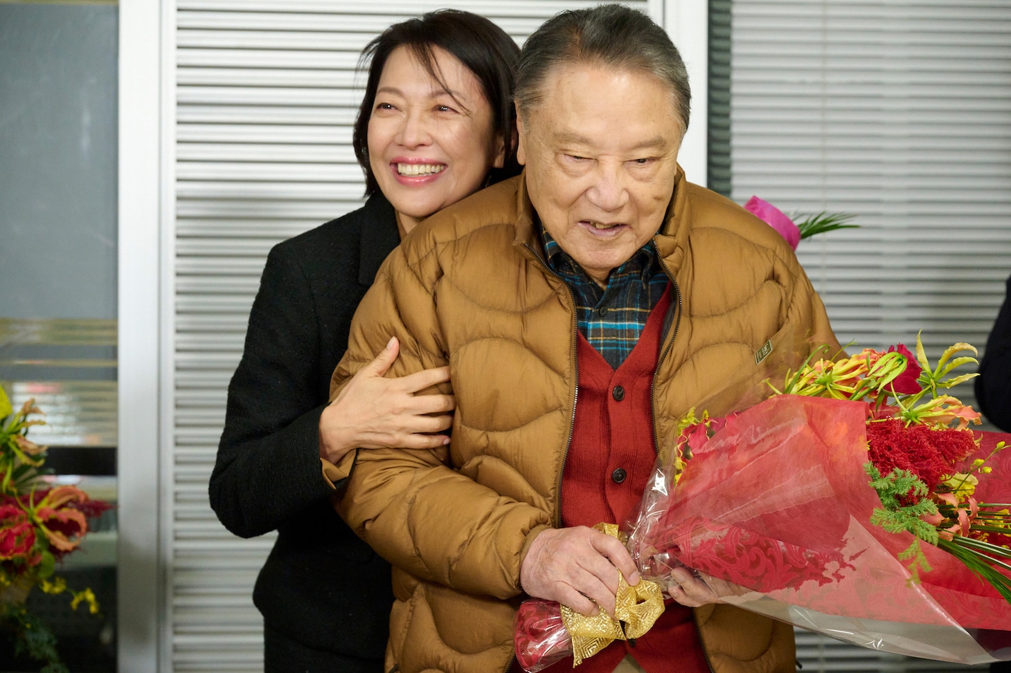 伊東四朗（手前）に抱きつく羽田美智子（奥）。