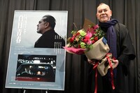 劇場スタッフから受け取った花束を手にするアンソニー・ウォン。