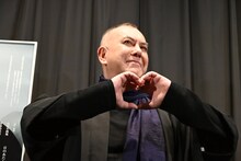 手でハートを作り、観客から歓声をあびるアンソニー・ウォン。