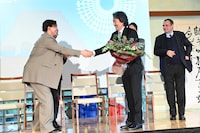 花束を受け取る役所広司（手前右）。