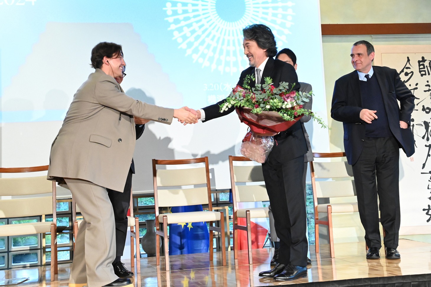 花束を受け取る役所広司（手前右）。