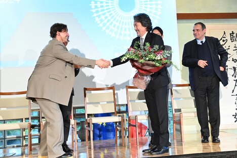 花束を受け取る役所広司(手前右)。