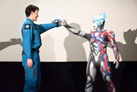 最終回で手をつなぐシーンを再現する蕨野友也とウルトラマンブレーザー。