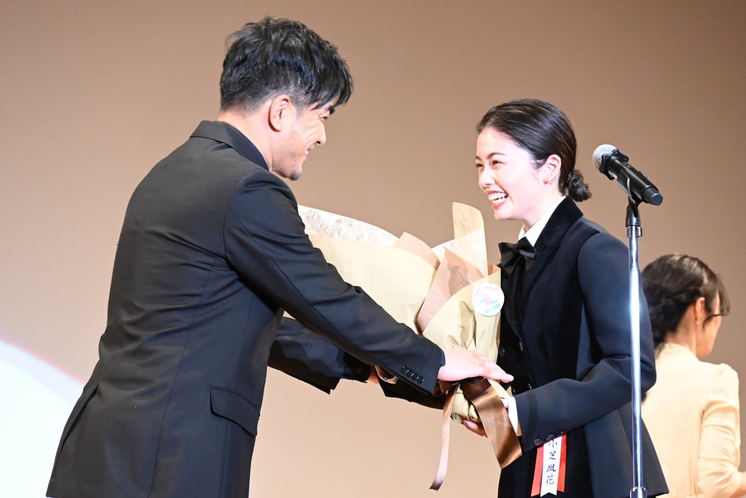 北村一輝（左）から花束を受け取る小芝風花（右）。