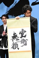 神妙な面持ちでタイトルを見せる大泉洋（右）。