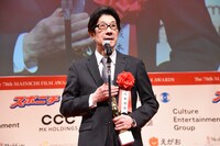 脚本賞のトロフィーを手にスピーチする阪本順治。