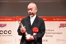 トロフィーを見つめる塚本晋也。