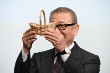 チョコレートを観客に見せる國村隼。