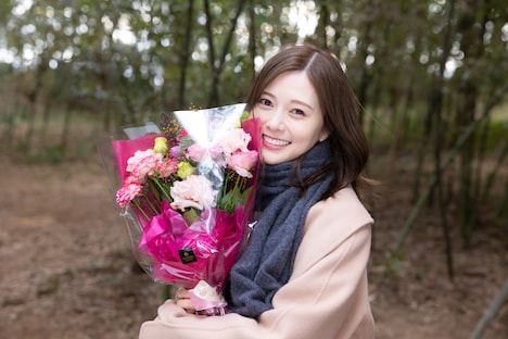 花束を抱えた白石麻衣。