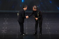 握手を交わす黒沢清（右）と是枝裕和（左）。