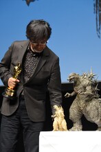 金のゴジラ像を、専用の台にそっと置いた山崎貴。