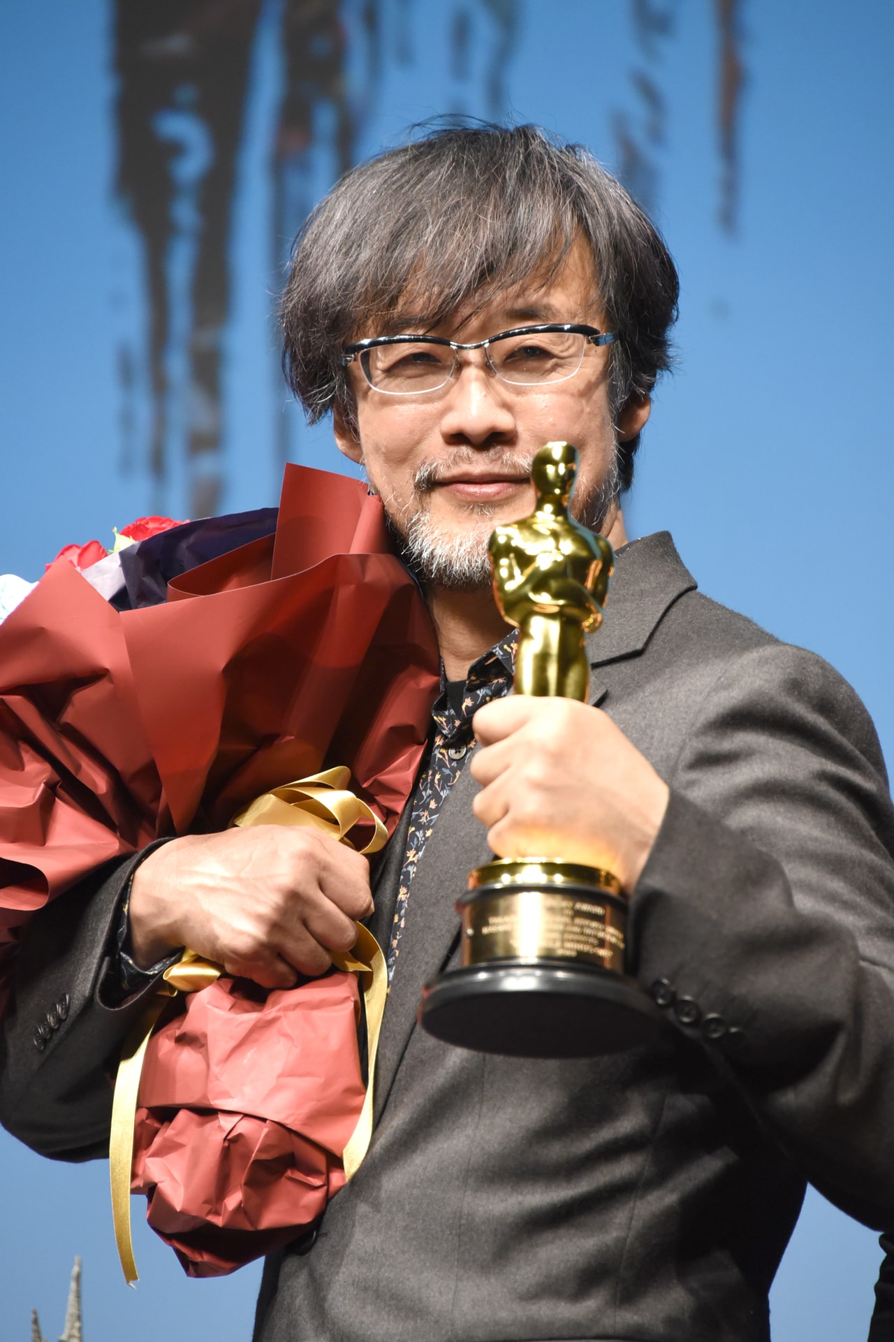 オスカー像を掲げる山崎貴。 第96回アカデミー賞（2024年） [フォト