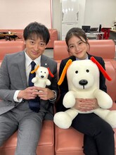 ドラマ「花咲舞が黙ってない」撮影現場にて、東京第一銀行のキャラクターである犬のダイチくんを抱える今田美桜（右）と山本耕史（左）。
