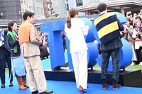 ブルーカーペットでサインをする「9ボーダー」のキャストたち。