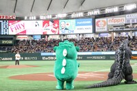 鈴木もぐら（奥）を見守るちびゴジラ（手前左）とゴジラ（手前右）。