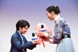 中須翔真（左）から花束を受け取る杏（右）。