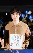 夢枕獏から贈られた色紙を持つ染谷将太。