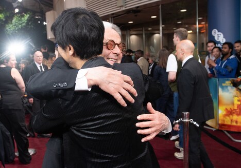 ハグを交わすジョージ・ミラー（奥）と小島秀夫（手前）。