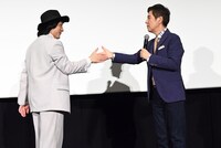 「ライド・オン」の好きなシーンを再現するジャッキーちゃん（左）と手伝う関根勤（右）。