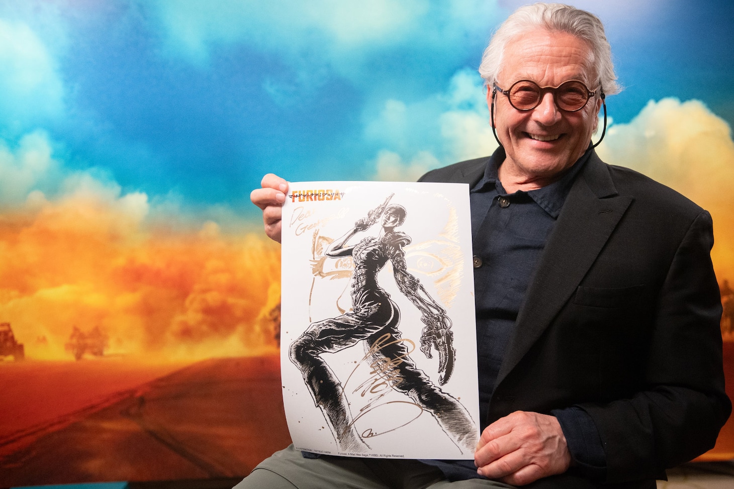 原哲夫からのイラストを手に笑顔を見せるジョージ・ミラー。