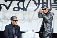 「僕はいっぱい撃ちたかったんです」と、マイクを使って銃の構え方を再現する柴田恭兵（右）。