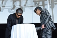 テーブルに隠された電話器を取り出す舘ひろし（左）と柴田恭兵（右）。