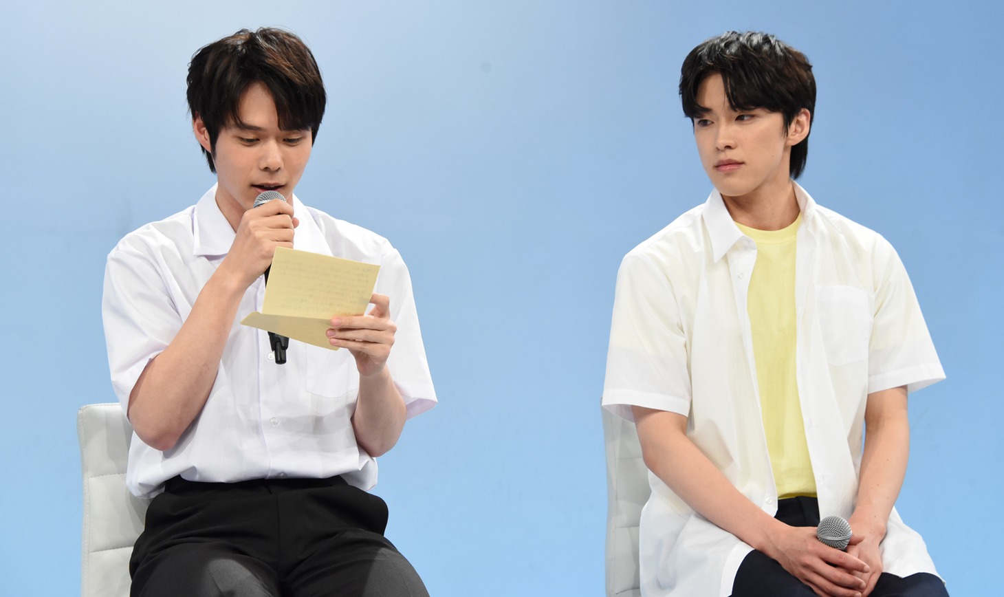 桜田ひよりのコメントを代読する細田佳央太（左）と、メモをそっとのぞく河野純喜（右）。