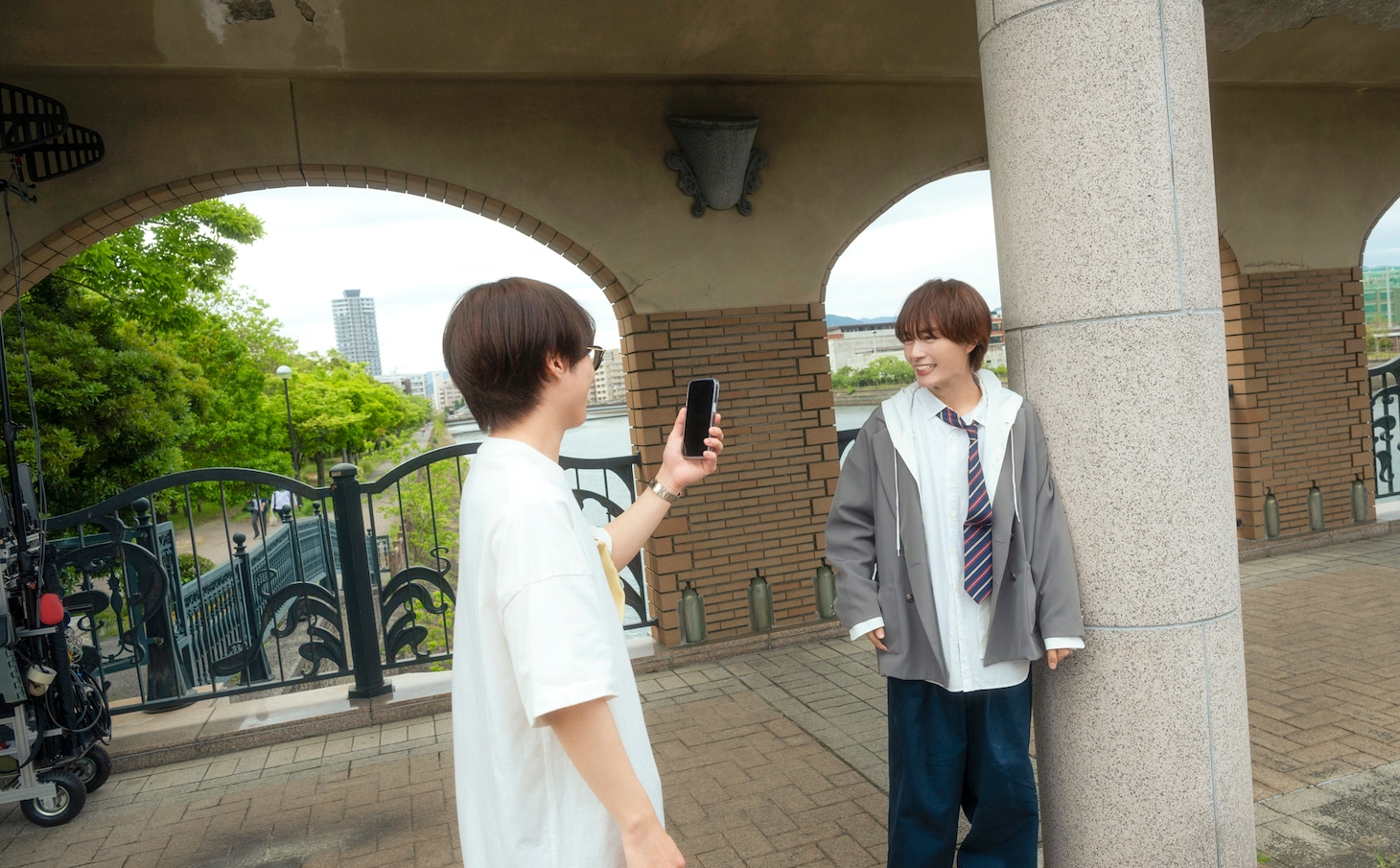 大西流星（奥）にスマートフォンを向ける大橋和也（手前）。