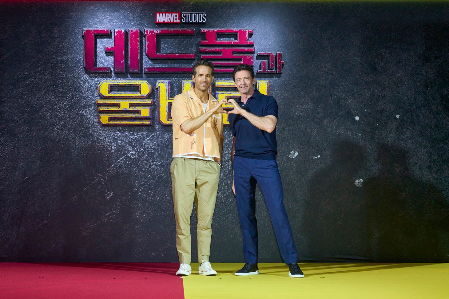 韓国で行われた映画「デッドプール＆ウルヴァリン」記者会見から。ハートマークを一緒に作るライアン・レイノルズ（左）とヒュー・ジャックマン（右）。