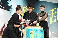 チェーンソーで鏡割りを行う一同。