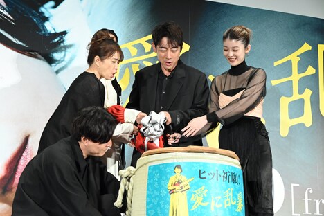 チェーンソーで鏡割りを行う一同。