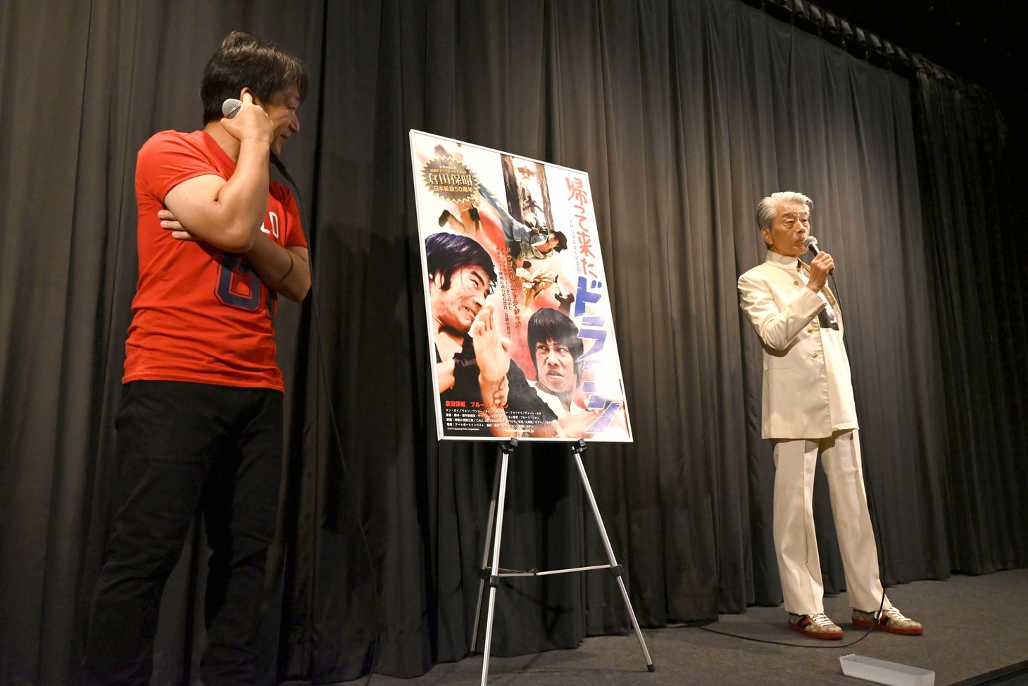 倉田保昭（右）に「手の届かない存在になった」と言われ、苦笑する谷垣健治（左）。