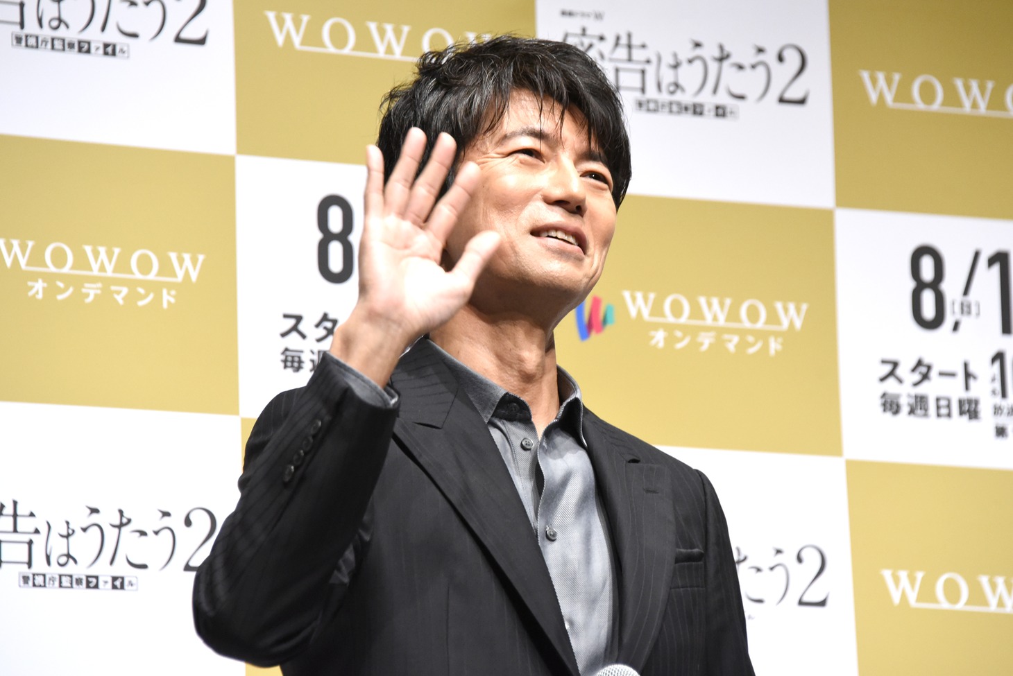 配信用のカメラに手を振る仲村トオル。