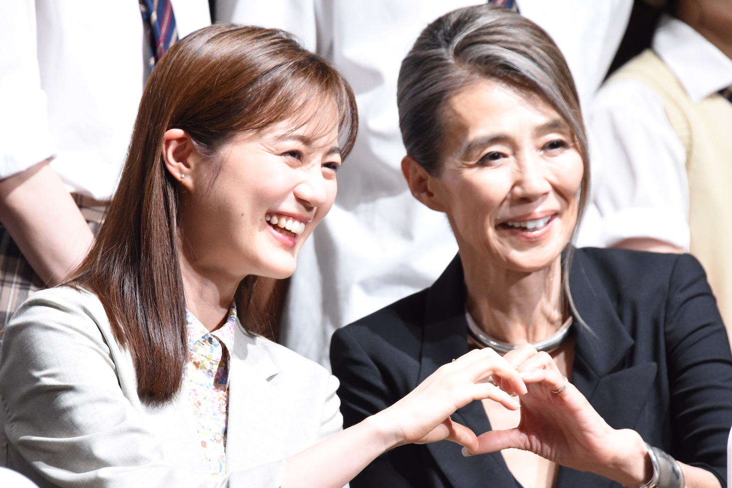 ハートマークを作る生田絵梨花（左）と萬田久子（右）。