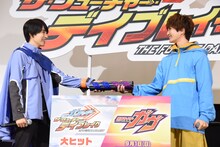 本島純政（左）からバトンを受け取る知念英和（右）。