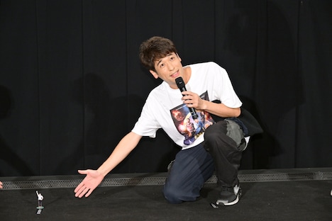 まっつん（岡田義徳）のアクリルスタンドを壇上に置く佐藤隆太。