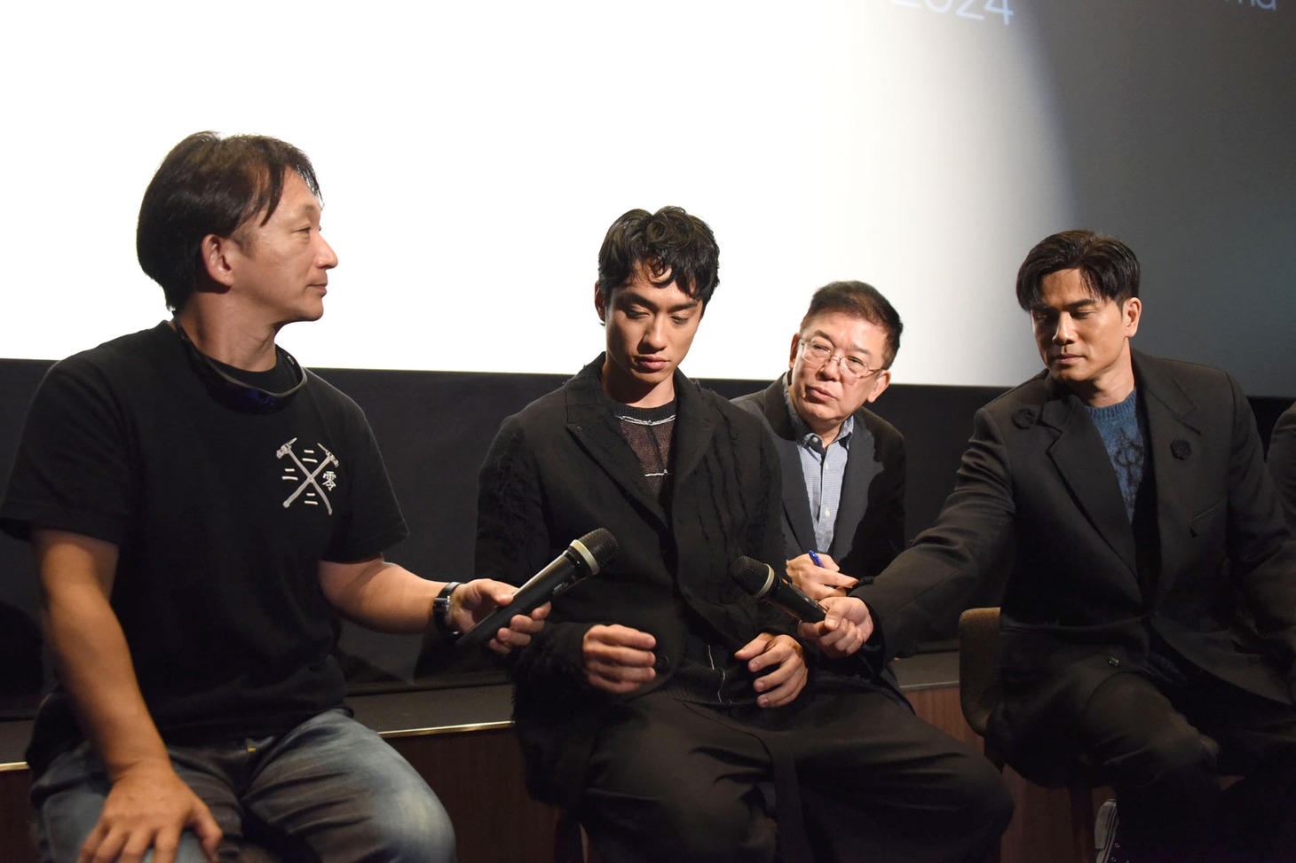 マイクを譲り合う谷垣健治（右）、テレンス・ラウ（中央）、フィリップ・ン（右）