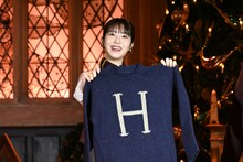 「H」のイニシャルが入ったセーターを手にする浜辺美波