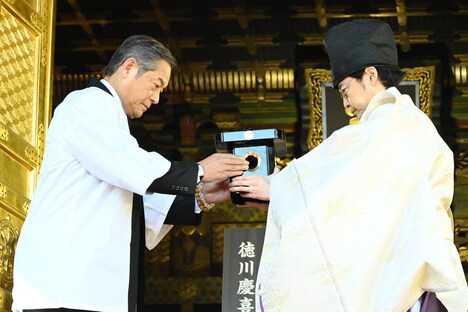 黒豆を嵯峨宮司（右）に手渡す松平健（左）