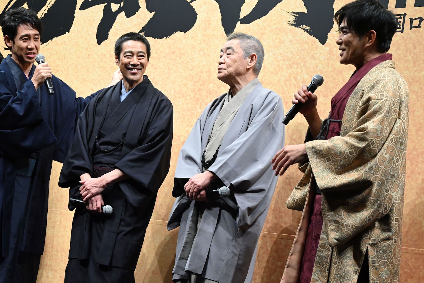 1人だけヒートテックを仕込んで撮影していた北村一輝（右）が、大泉洋（左）から咎められる様子