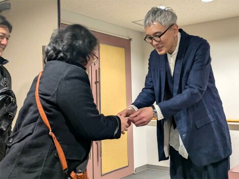 「劇映画 孤独のグルメ」上映会の参加者にプレゼントを手渡す松重豊