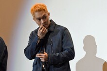 舞台挨拶中にリップクリームを塗る自然体なトニー・ウー