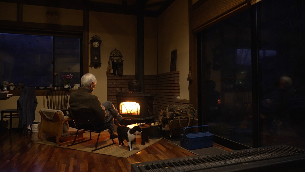 薪ストーブで暖を取る近藤正臣