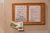 「事故物件ゾク 恐い間取り」セットより、シェアハウスの内部。掲示物には居住ルールなどが細かく書かれている