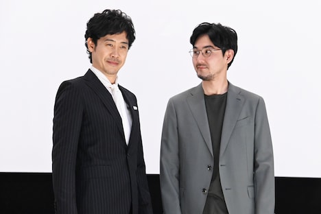 フォトセッション中にもかかわらず大泉洋(左)をじっと見て、観客を笑わせる松田龍平(右)