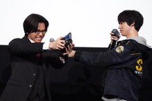 変身ポーズをする金田昇（左）にマイクサポートする戸塚有輝（右）