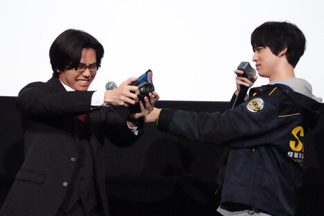 変身ポーズをする金田昇（左）にマイクサポートする戸塚有輝（右）